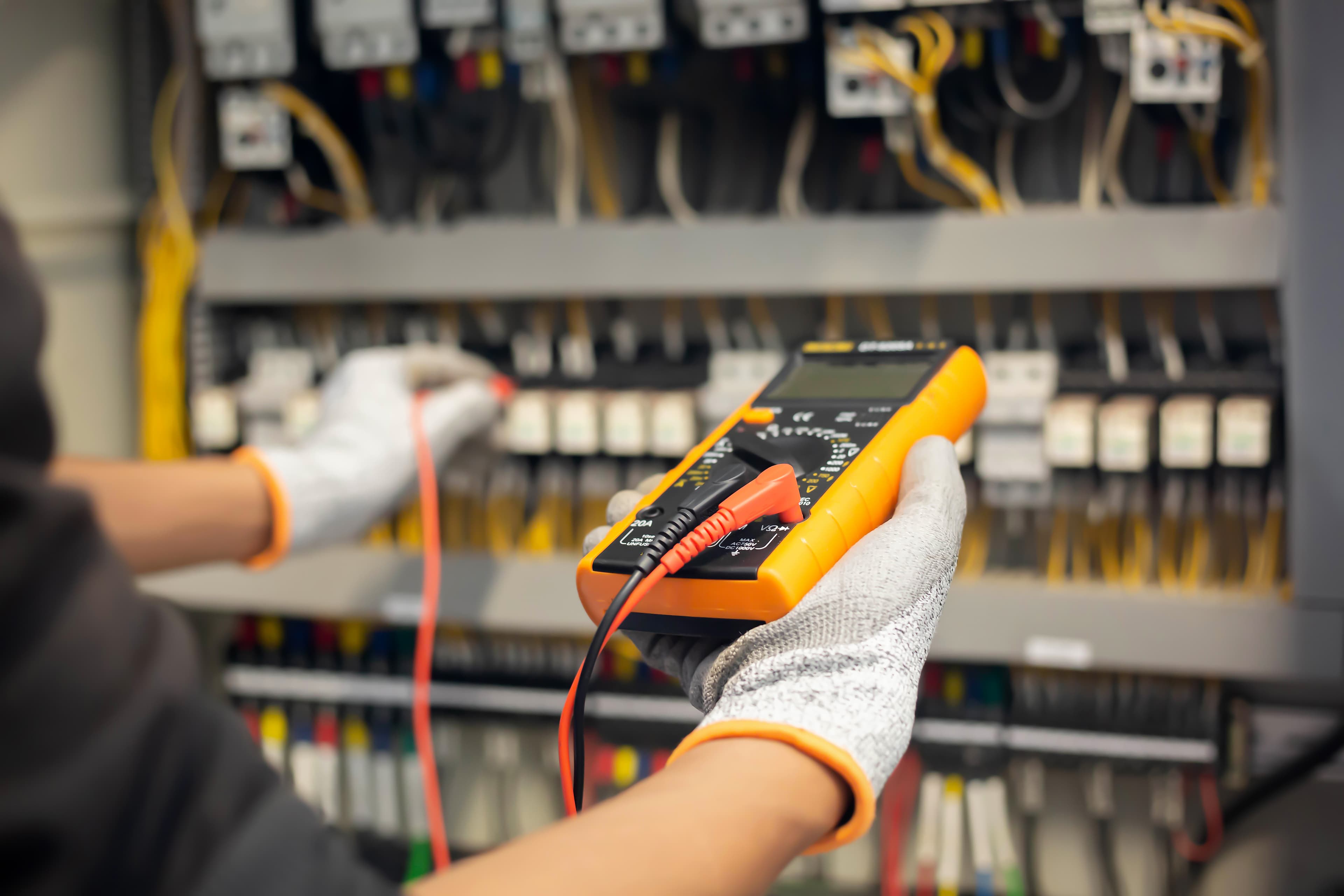 Crop focused ethnic engineer using electric screwdriver